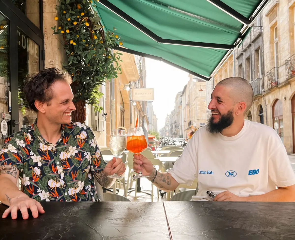 Roland et Bastien, les fondateurs, trinquent en terrasse sous le store vert du bistrot